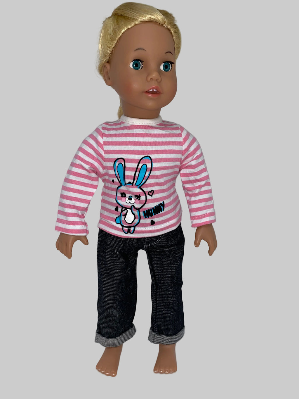  18 inch doll wearing pink and white horizontal striped cotton long-sleeve shirt with blue and pink bunny graphic and Hunny text, paired with dark denim cuffed jeans, front view on plain background