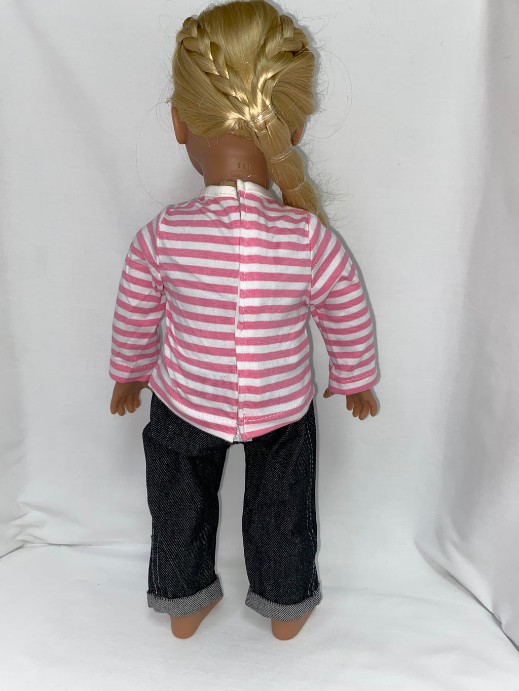 Back view of 18 inch doll in pink and white striped long-sleeve shirt with velcro closure and dark denim cuffed jeans, showing rear construction detail of doll clothes